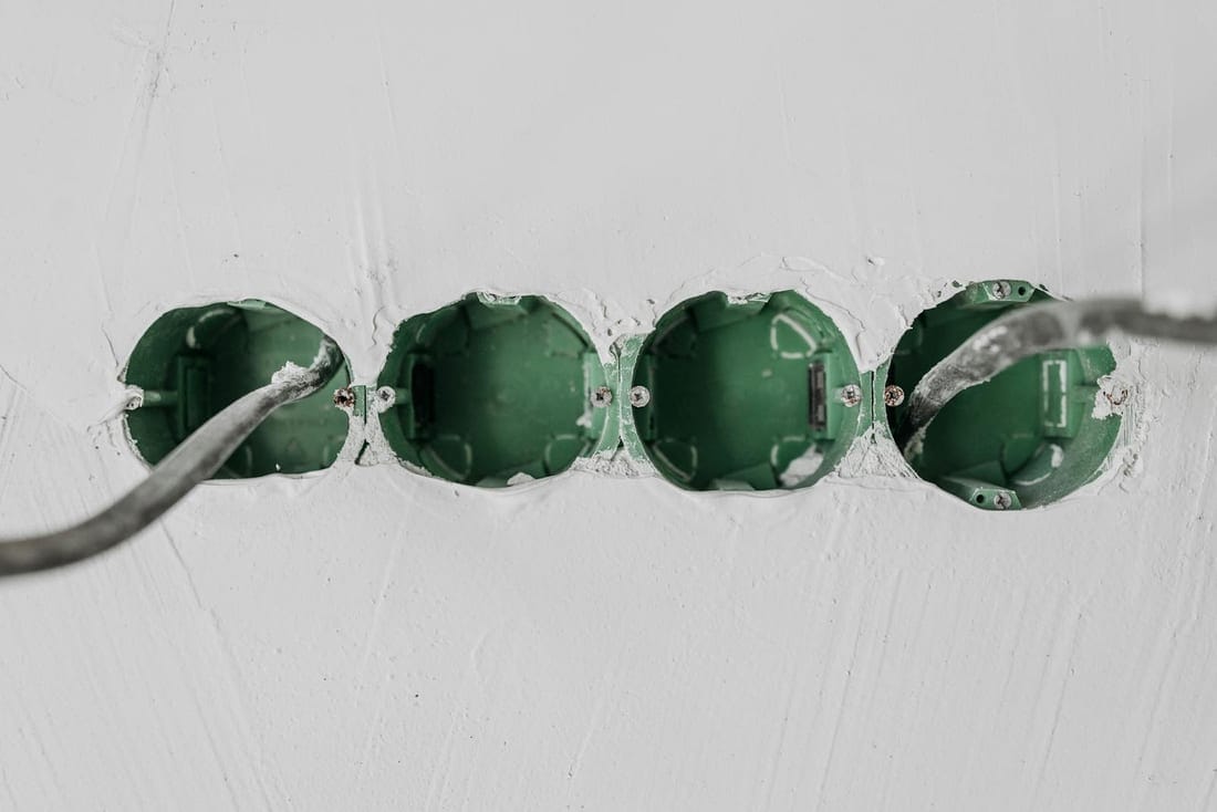 Green electrical boxes with wiring installed in a wall during a fit-out - typical concealed-wiring or rewiring project in an Ulkanagari home