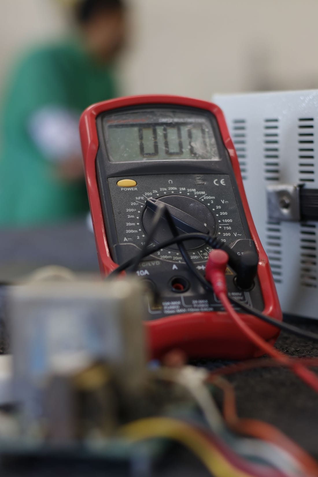 Close-up of a digital multimeter measuring mains voltage at a residential outlet - the first check before recommending a stabilizer