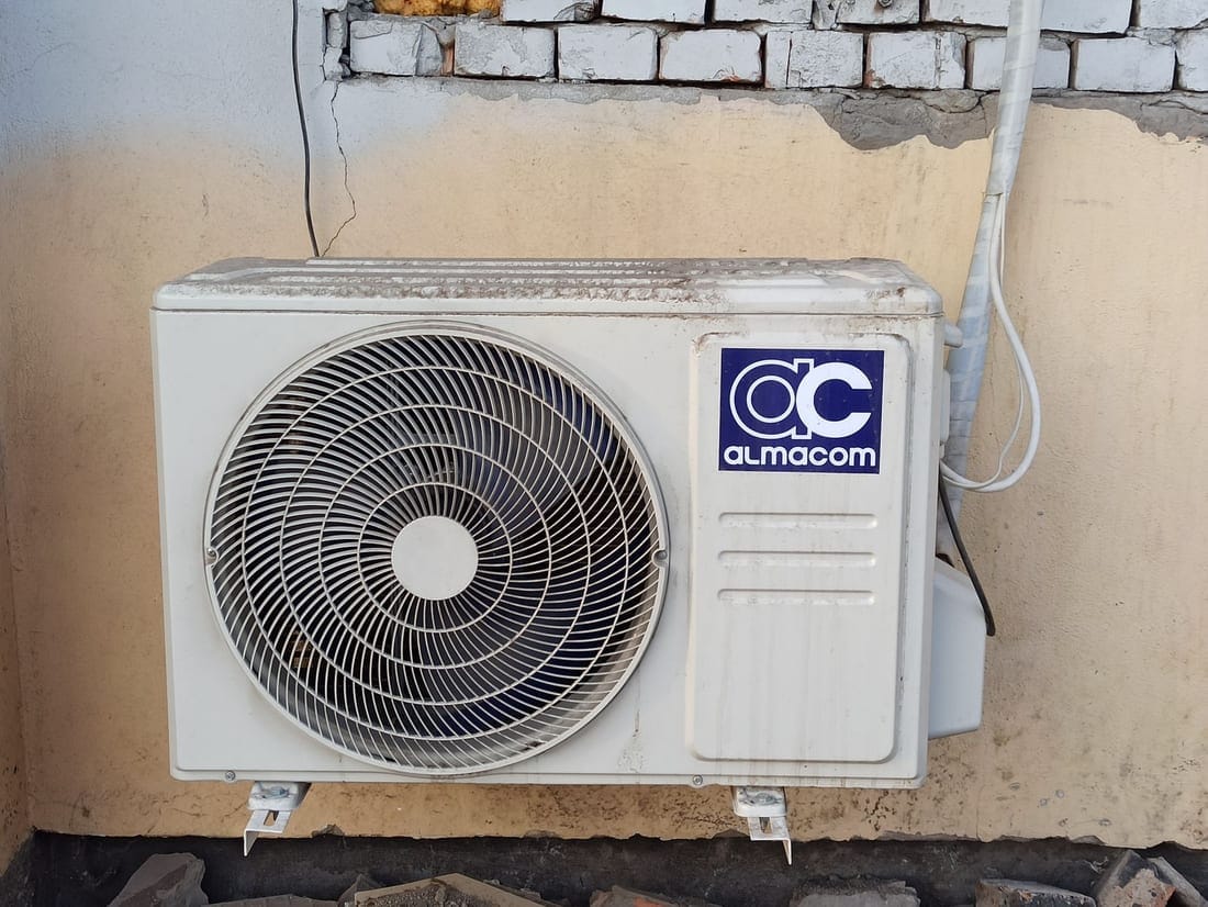 Wall-mounted split AC outdoor unit on a residential brick wall in India - the kind of installation that needs proper voltage stabilizer protection in Chh. Sambhajinagar (Aurangabad)