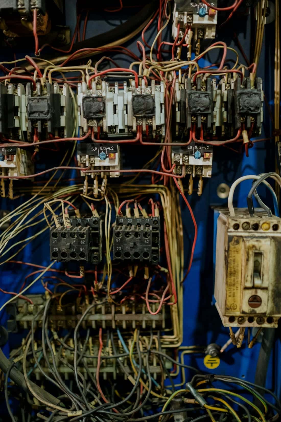 Close-up of dense, tangled wiring inside an electrical distribution panel - the kind of cabling that hides loose connections and overload risks