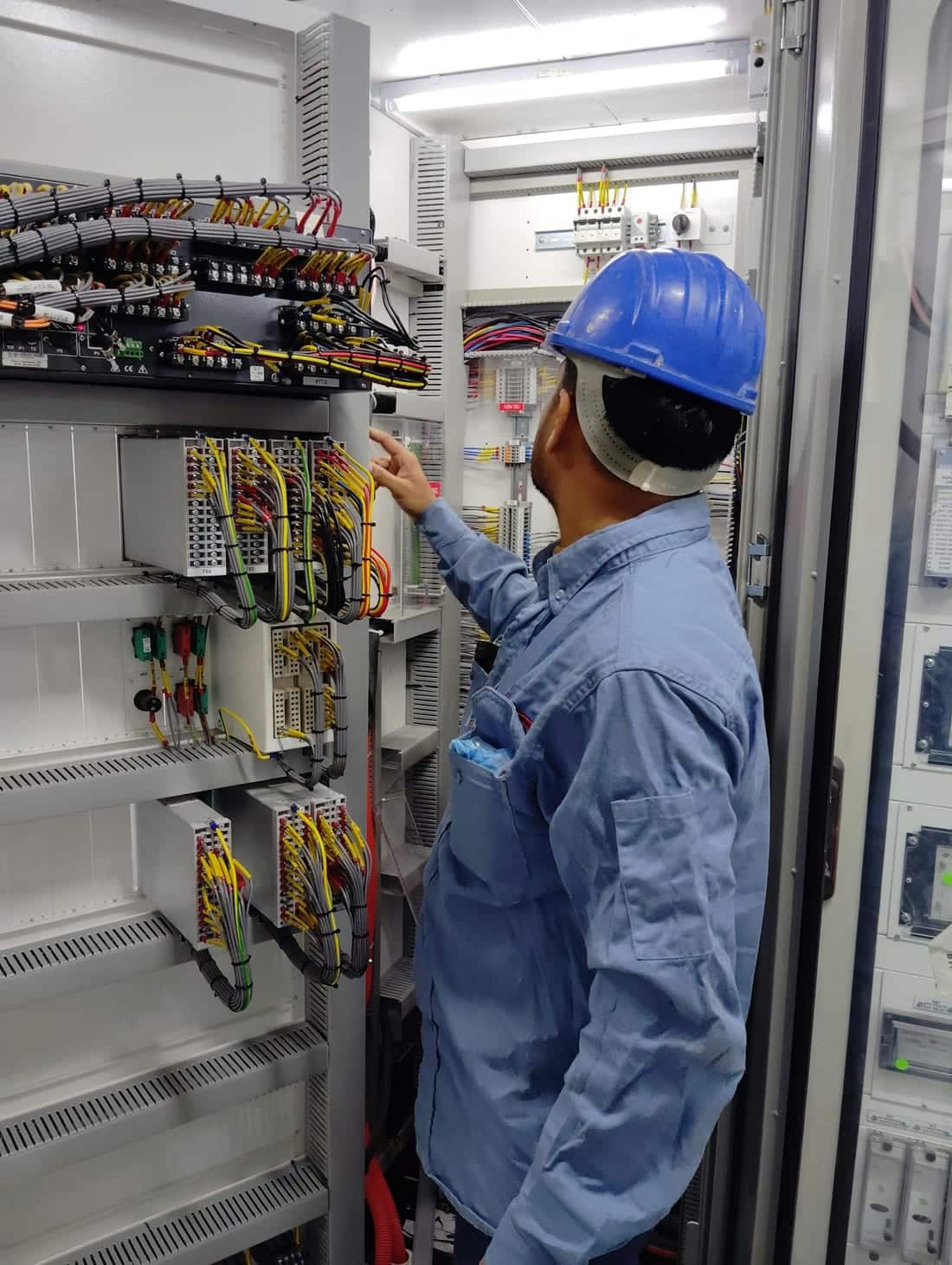 Indian electrician in a hard hat inspecting an industrial control panel inside a factory - Shaats Electrical preventive maintenance visit in MIDC, Chh. Sambhajinagar (Aurangabad)