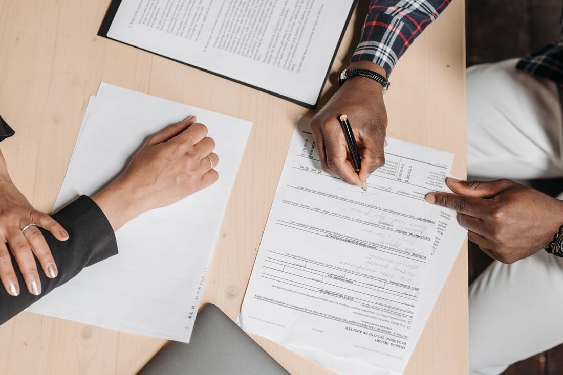 Application forms and supporting documents being worked through at a desk - the paperwork stage of an electrical contractor licence and PWD registration in Maharashtra