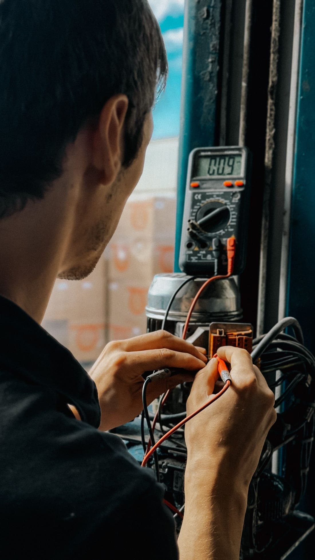 Technician measuring electrical resistance with a multimeter in a workshop - IS 3043 earthing verification by Shaats Electrical in Chh. Sambhajinagar (Aurangabad)
