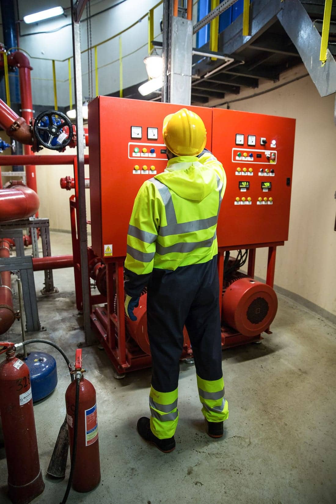 Factory worker in safety gear operating an industrial control panel - typical scene during a Shaats Electrical APFC bank installation in a Waluj MIDC unit