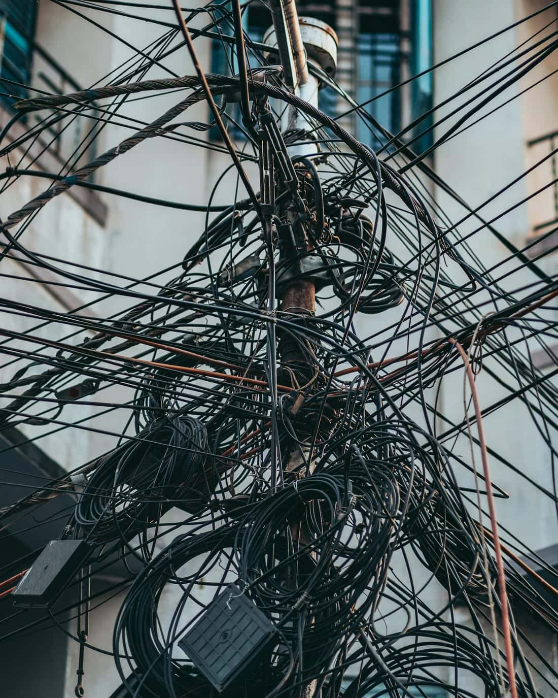 Chaotic tangle of overloaded electricity wires on an urban Indian street utility pole - a real-world example of overload and short-circuit fire risk