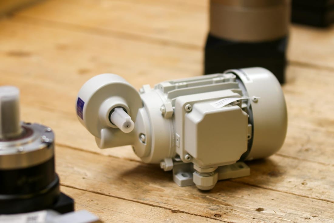 White industrial induction motor on a workshop bench awaiting inspection after a burnout - Shaats Electrical motor diagnostics for Waluj and Shendra MIDC factories
