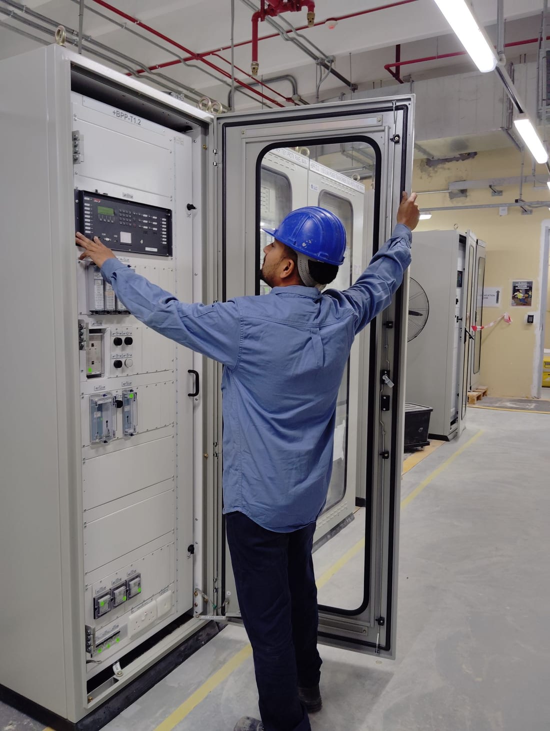 MIDC factory electrical panel with a technician performing inspection -- the kind of structured maintenance visit that prevents production downtime in Waluj and Shendra industrial units