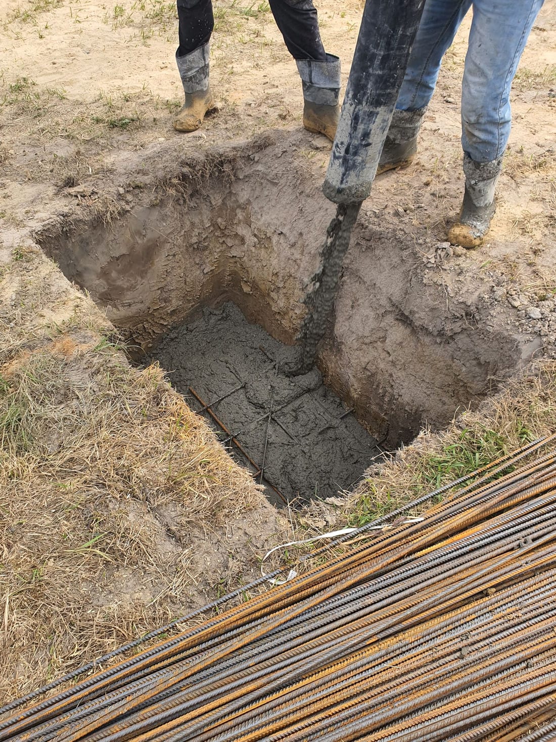 Worker at ground level during outdoor electrical installation work - earth electrode installation and earthing pit work for IS 3043 compliant industrial earthing systems