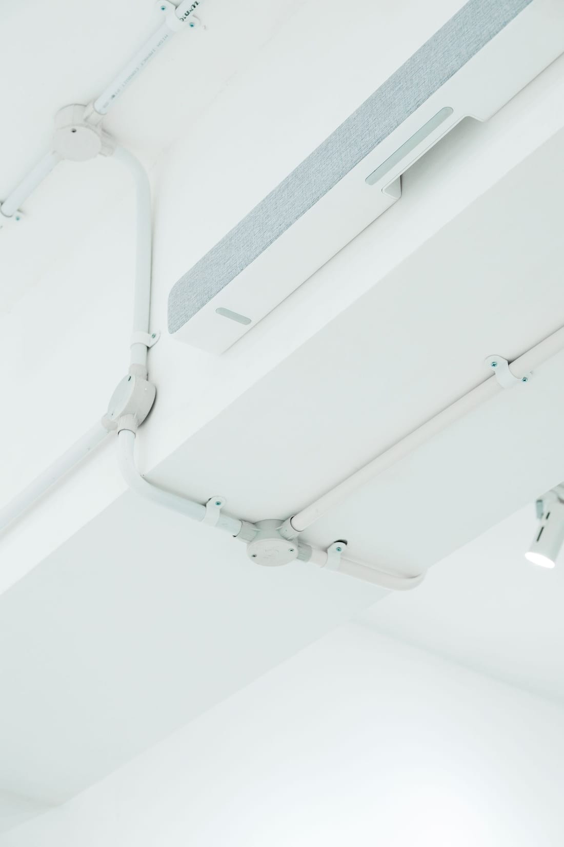 Exposed electrical conduit and lighting fixtures on a commercial building ceiling - IS 732-compliant conduit wiring installed in government and institutional buildings