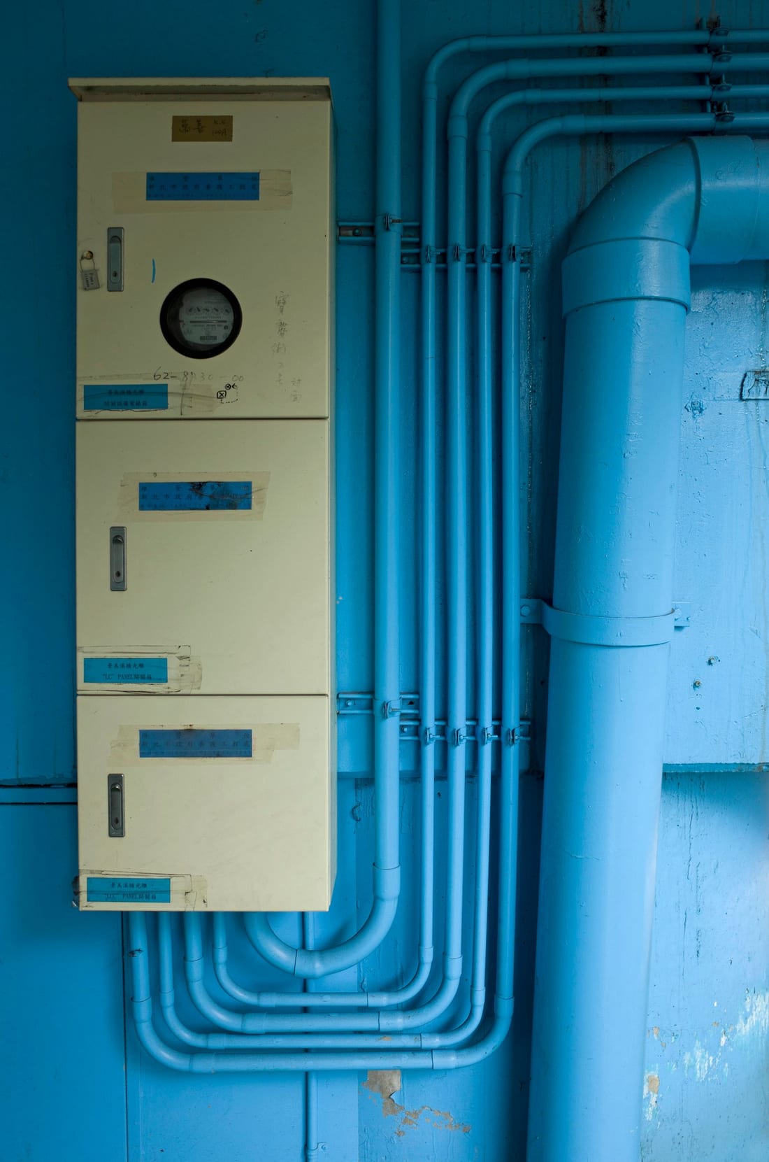 Electric distribution board with pipes in a utility room - the kind of pump room and meter room electrical that forms the core of housing society maintenance
