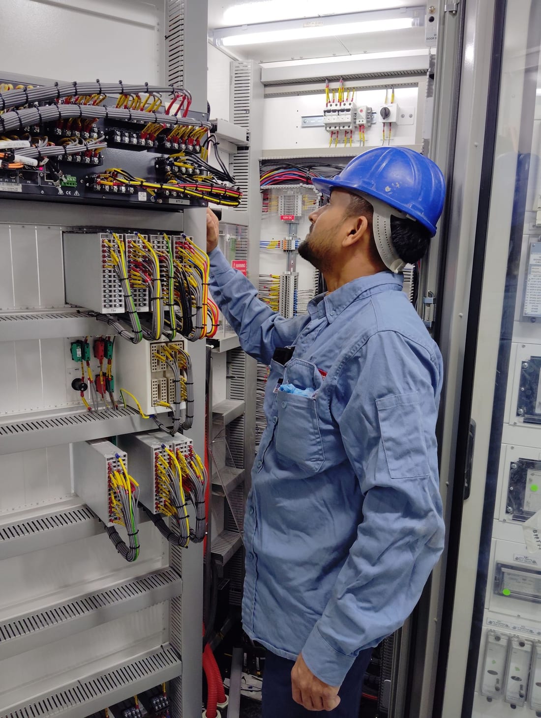 Two engineers working together at an industrial control panel during commissioning - MCC and PCC panel installation and testing by Shaats Electrical