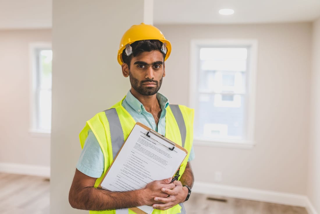 Safety professional with hard hat and clipboard conducting a systematic site inspection - the methodical walk-through approach used in every Shaats Electrical safety audit